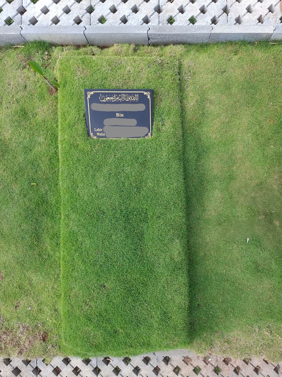 Tampak atas makam dengan nisan dan rumput terawat